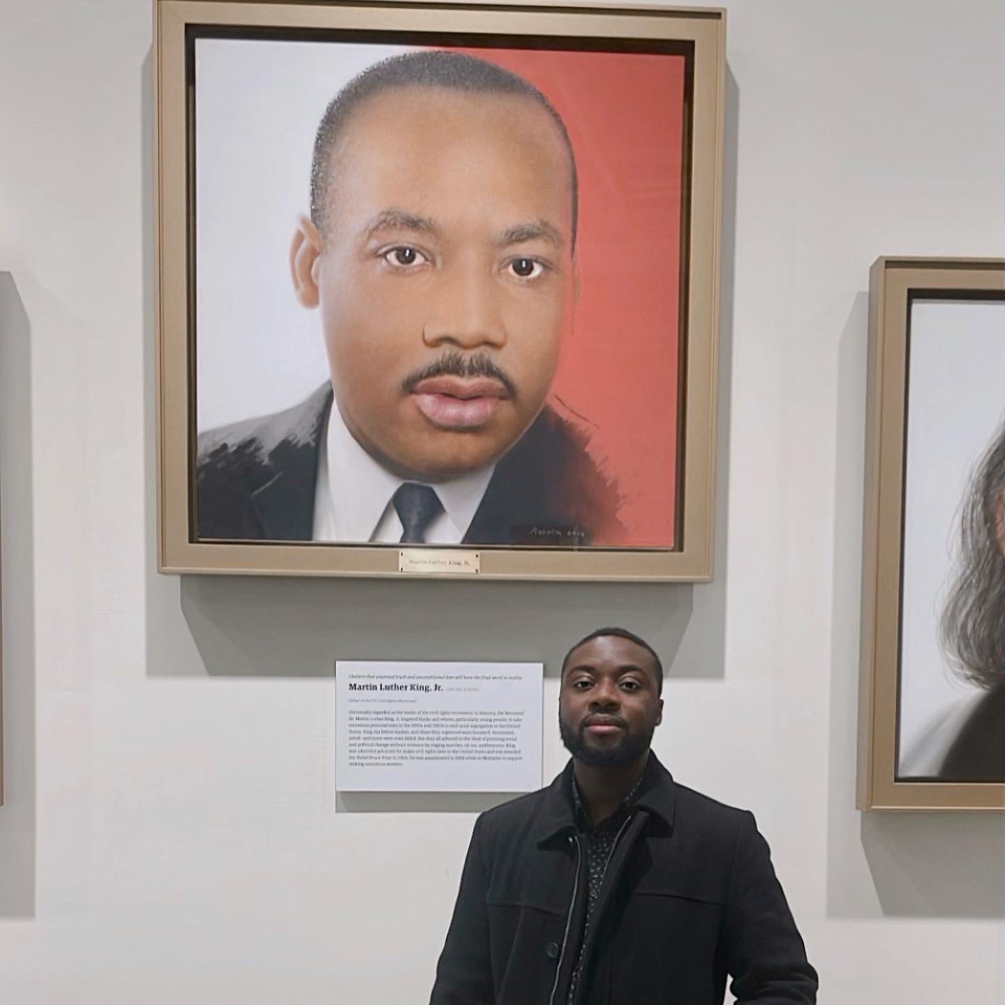Martin Toe standing beneath a portrait of Dr. Martin Luther King Jr.